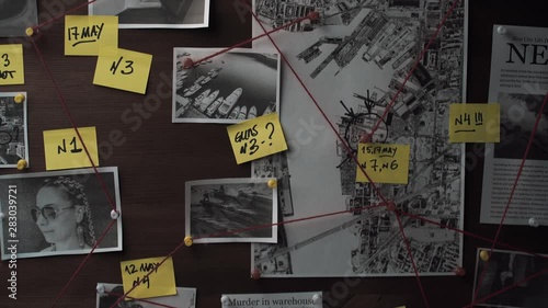 Detective board with photos of suspected criminals, crime scenes and evidence with red threads