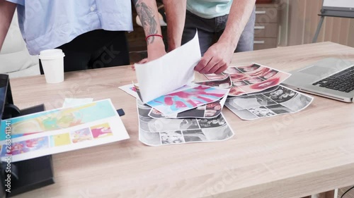 Close up of two art directors checking different ideas for their next marketing meeting. Creative room.