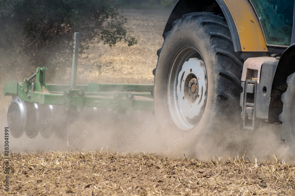 Fototapeta premium Tractor cultivating the field