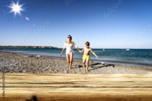 Table background and people walking and running on the beach. Empty space for decoration and advertising products.