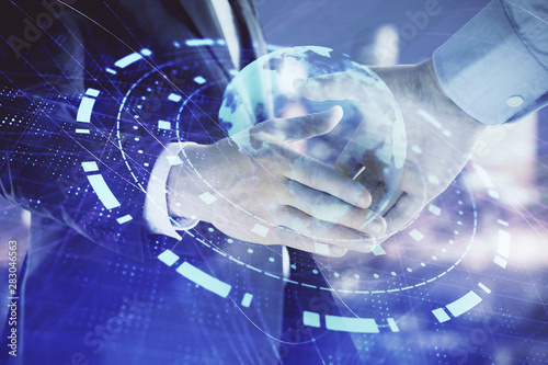 Double exposure of world map on cityscape background with two businessmen handshake. Concept of international business