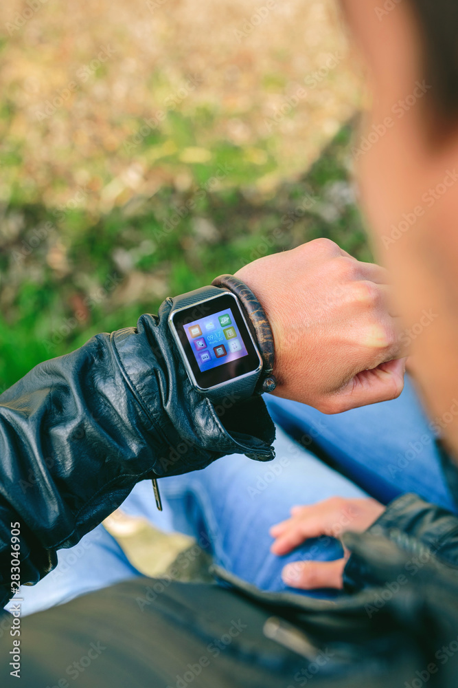 Fototapeta premium Detail of hand of unrecognizable young man looking at his smartwatch
