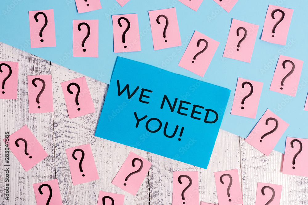 Word writing text We Need You. Business photo showcasing asking someone to work together for certain job or target Scribbled and crumbling papers with thick cardboard above wooden table