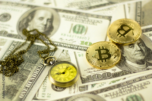 Bitcoin and pocket watch over the dollar bills