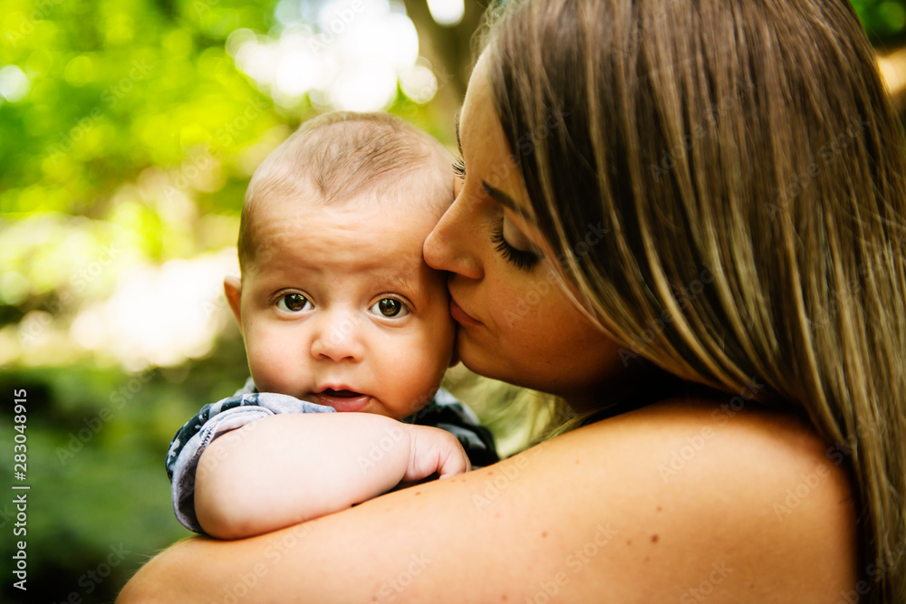 Happy mother having fun with his baby son on the park Happy mother having fun with his baby son on the park