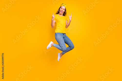 Full body photo of beautiful lady jumping high rejoicing at metal concert wear casual clothes isolated yellow background