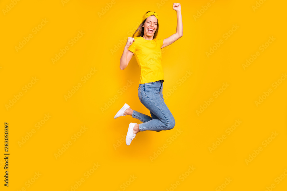 Full length photo of beautiful lady jumping high celebrating first place wear casual clothes isolated yellow background Full length photo of beautiful lady jumping high celebrating first place wear casual clothes isolated yellow background