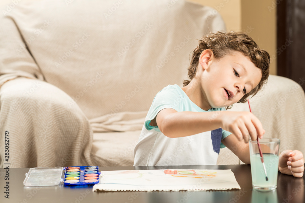 Child painting with watercolors on paper. Child painting with watercolors on paper.