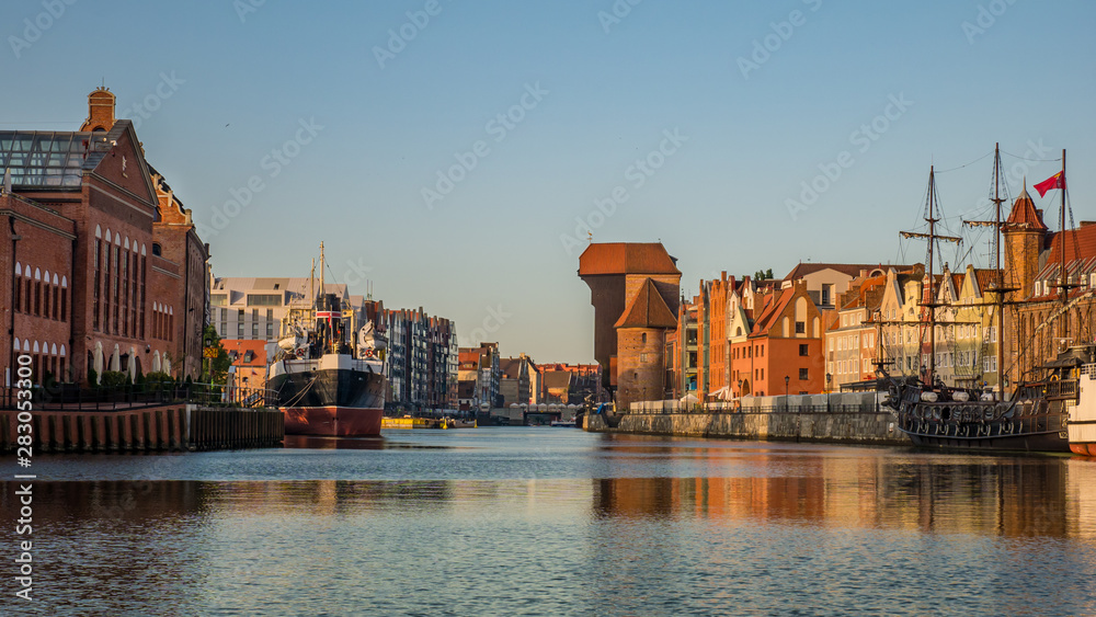 City Gdansk with the oldest medival port crane called Zuraw and a promenade along the riverbank of Motlawa River.