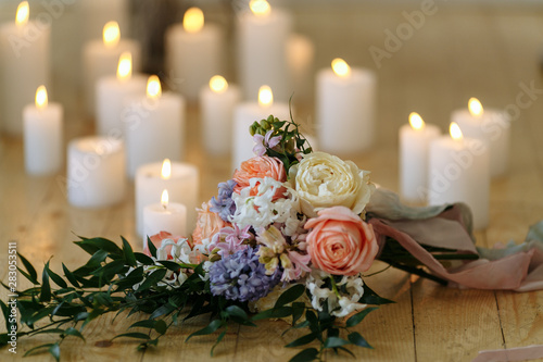 wedding bouquet on the floor with many candles © Andrii