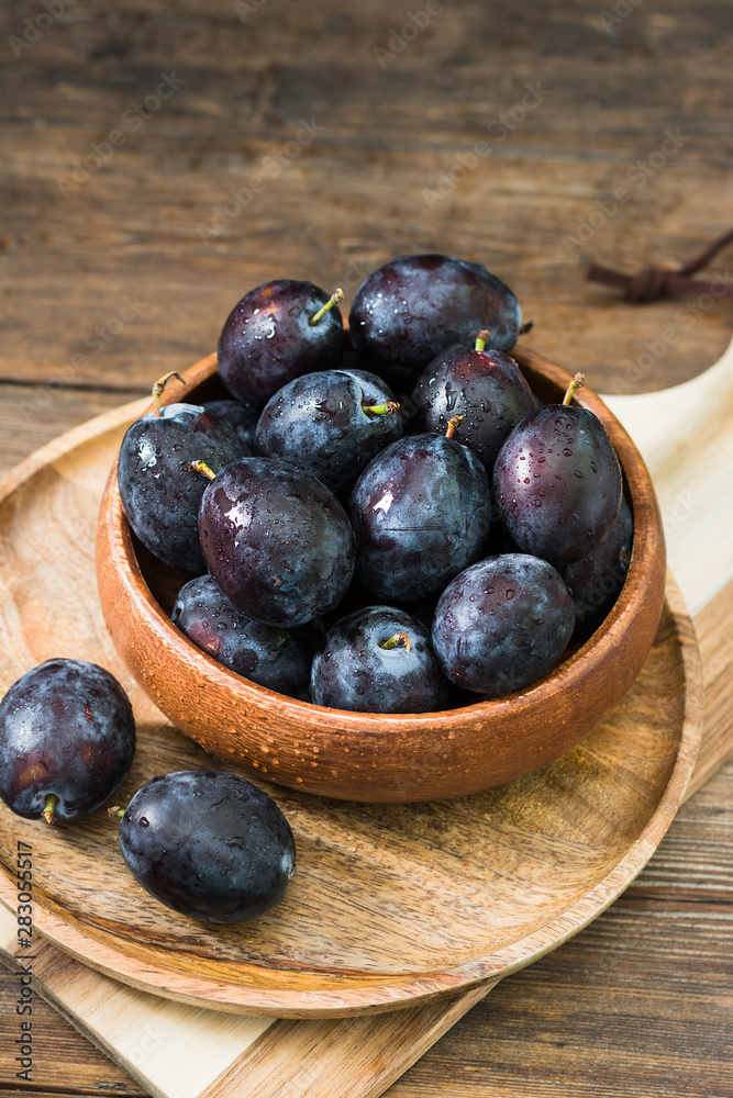 Juicy plums wooden utensils on a wooden table. Rustic style Juicy plums wooden utensils on a wooden table. Rustic style