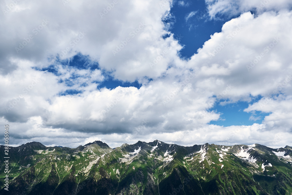 perfect mountain landscape with green mountain range and blue sky with white clouds