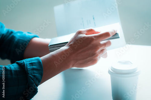 Man reading book, white coffee cup on white table, close-up photography