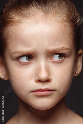 Close up portrait of little and emotional caucasian girl. Highly detail photoshot of female model with well-kept skin and bright facial expression. Concept of human emotions. Sad  upset.