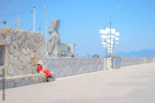 赤いワンピースを着た女性が座っている　女木島　旅行