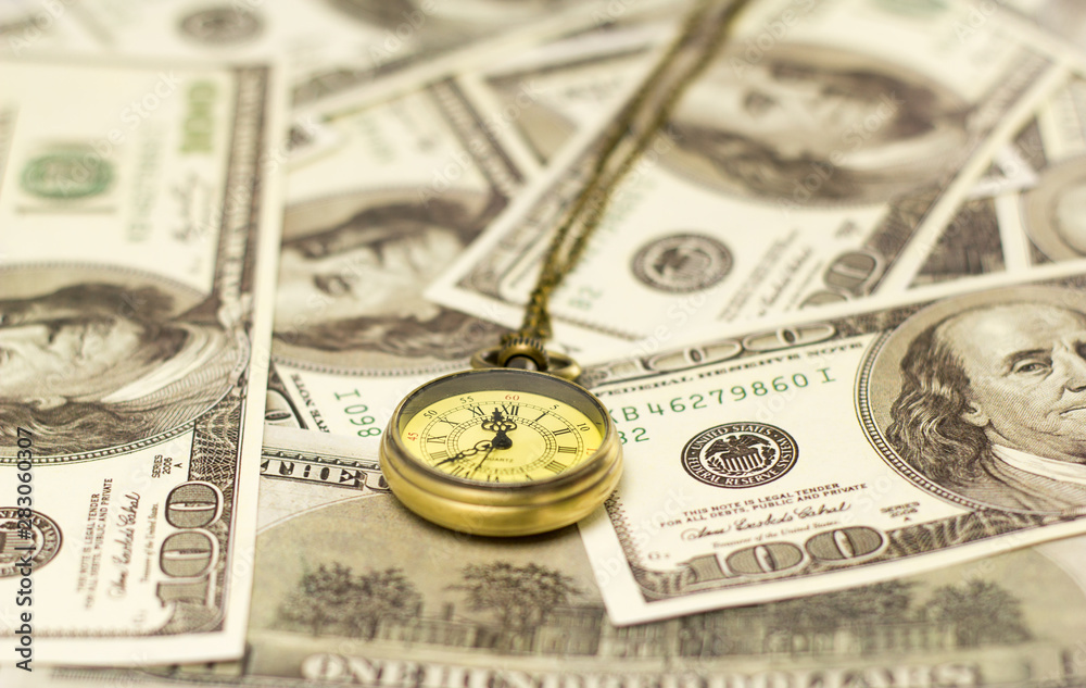 pocket watch and US dollar banknotes pocket watch and US dollar banknotes