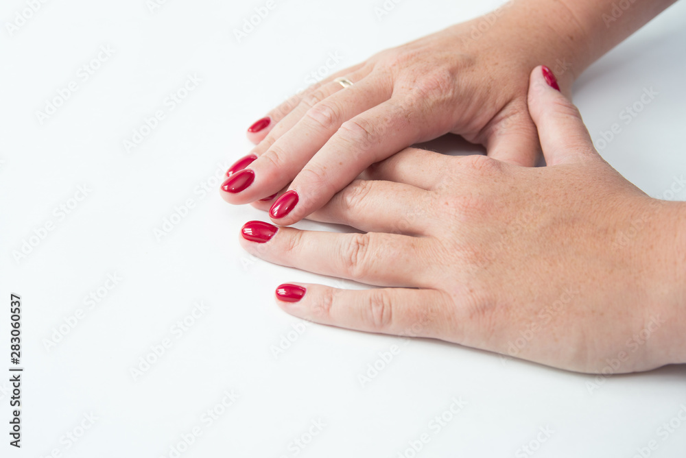Beautiful woman's hands on light background. Care about hand. Redl manicure, clean skin. Bright nails with polish on white background Beautiful woman's hands on light background. Care about hand. Redl manicure, clean skin. Bright nails with polish on white background