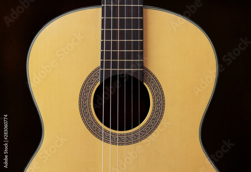 Close-up Wooden Spanish classic guitar with nylon string on the dark background