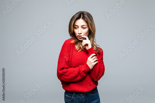 Canvas Print Young woman thinking an idea with red sweater over isolated on gray background