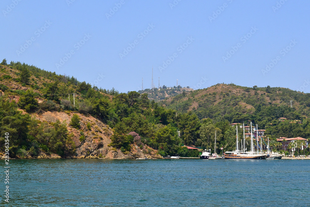Naklejka premium June 17, 2019 Fethiye Turkey, - View from the ship on the coastal mountains covered with forest
