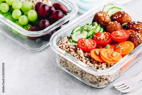 Meal prep lunch box containers with quinoa, meatballs cucumbers, carrots and pumpkin seeds