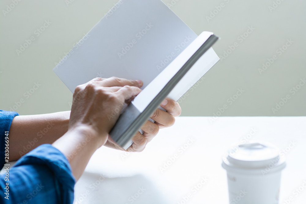 Man reading book with copy space for text, cup of coffee on table Man reading book with copy space for text, cup of coffee on table