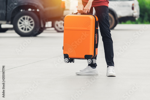 Woman tourist with orange suitcase at station background. travel, tourist, vacation concept.