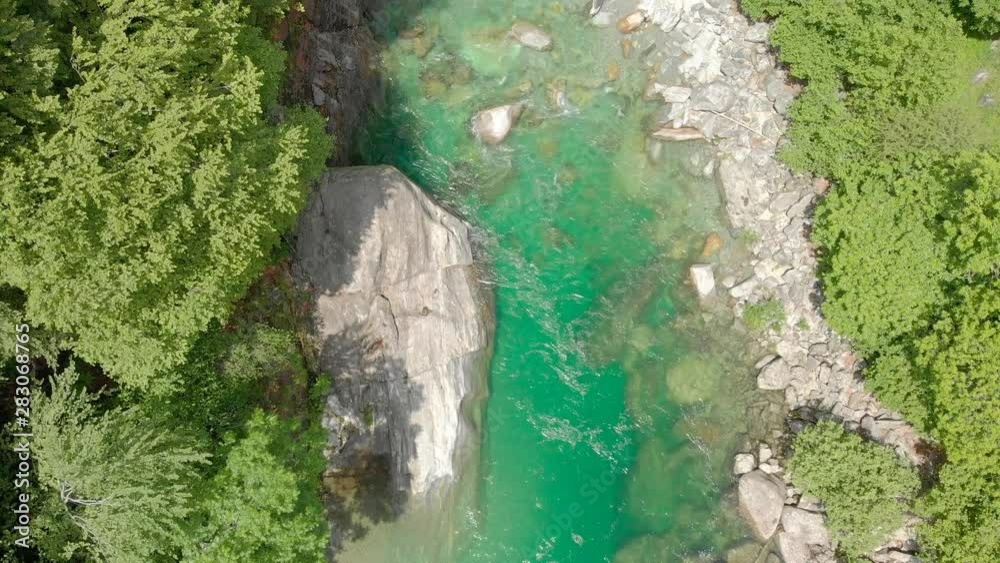 Valle Verzasca - Aerial View of clear and turquoise water stream and rocks in Verzasca River in Ticino - Verzasca Valley in Tessin, Switzerland Valle Verzasca - Aerial View of clear and turquoise water stream and rocks in Verzasca River in Ticino - Verzasca Valley in Tessin, Switzerland