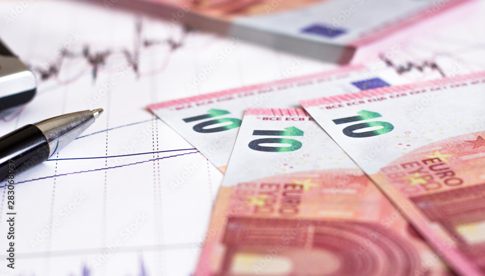 European Retail prices graphics. euro bills on the graph. Pen,calculator near heap of euro coins. Concept of retail trading European Retail prices graphics. euro bills on the graph. Pen,calculator near heap of euro coins. Concept of retail trading