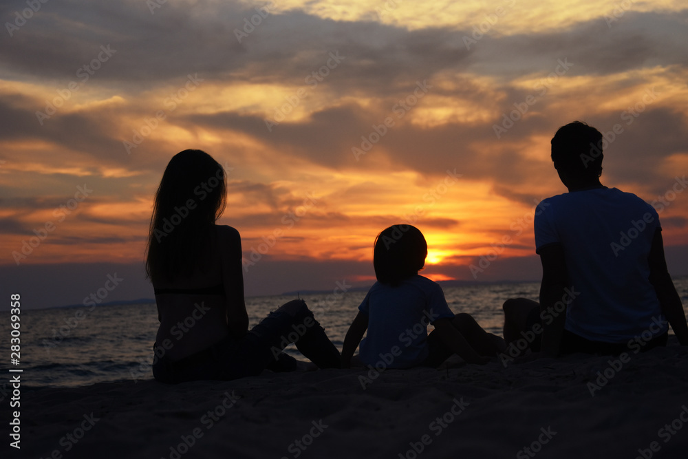 Silhouette of family watching sunset at beach. Happy family enjoy on sea on summer vacation