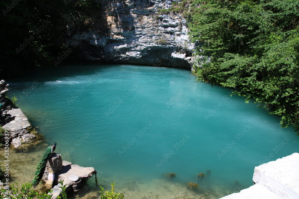 Obraz premium The Blue lake in Caucasian mounts and peafowls on the shore