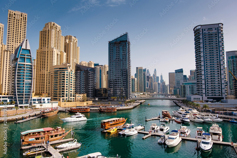 Obraz premium Dubai marina with boats and buildings with gates, United Arab Emirates