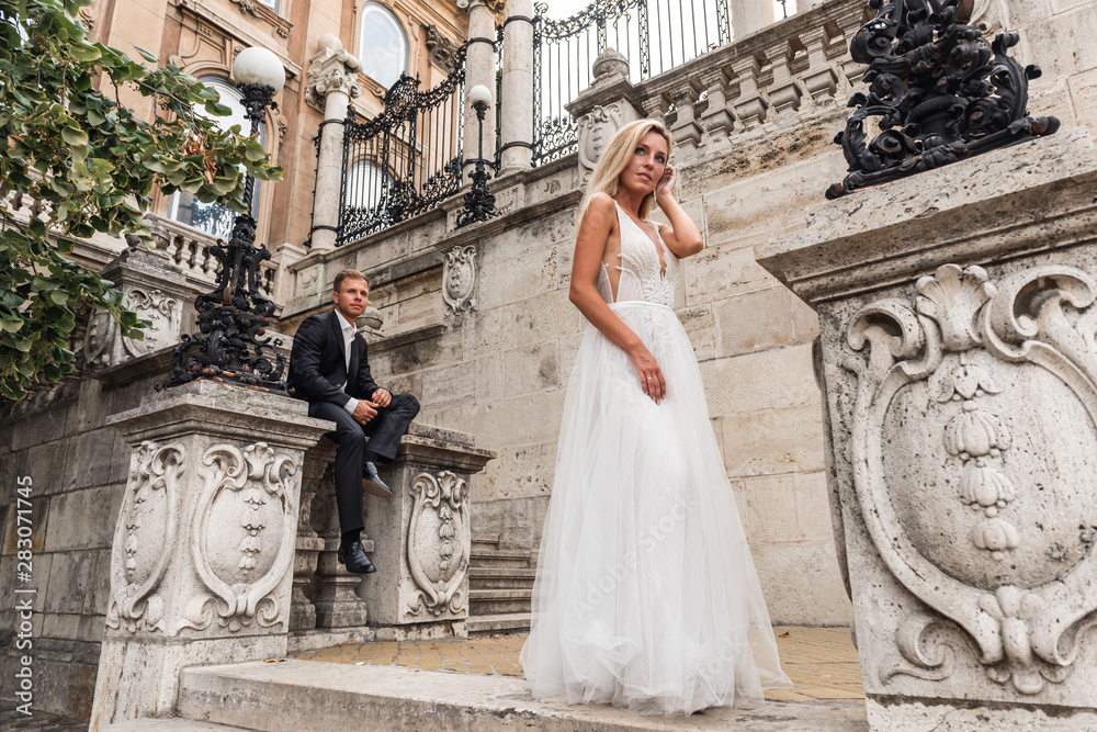 Bride and groom hugging in the old town street. Wedding couple in love. Luxury rhinestone dress. Hot summer days. Bride and groom hugging in the old town street. Wedding couple in love. Luxury rhinestone dress. Hot summer days.