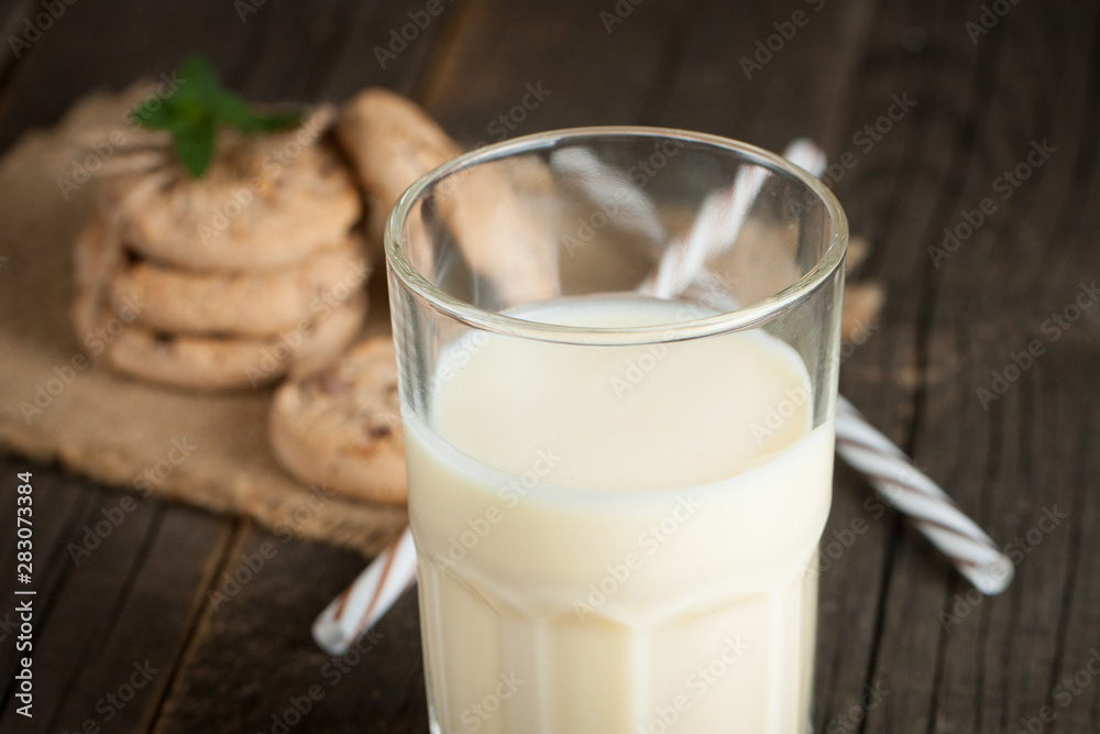 Photo of fresh Made Chocolate Banana Smoothie on a wooden table with cookies, banana and coconut. Milkshake. Protein diet. Healthy food concept. Photo of fresh Made Chocolate Banana Smoothie on a wooden table with cookies, banana and coconut. Milkshake. Protein diet. Healthy food concept.