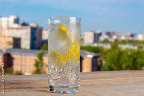 Homemade lemonade on a wooden desk on the background of a blurry cityscape