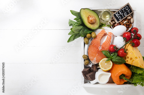Ketogenic low carbs diet - food selection on white background. Balanced healthy organic ingredients of high content of fats for the heart and blood vessels. Meat, fish and vegetables. Copyspace.