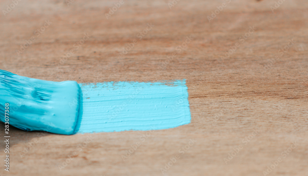 painting a wooden surface. blue paint on the brush painting a wooden surface. blue paint on the brush