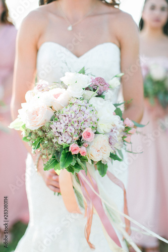 bride and bridesmaids holding wedding bouquets, pink dresses