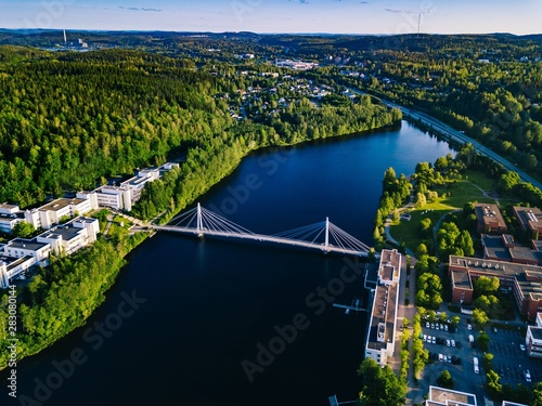 Fényképezés Aerial view of blue lake with cable-stayed bridge and green summer town in Finland