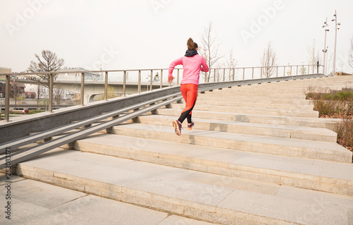 healthy lifestyle sports woman running up on stone stairs at sunrise seaside © yavdat