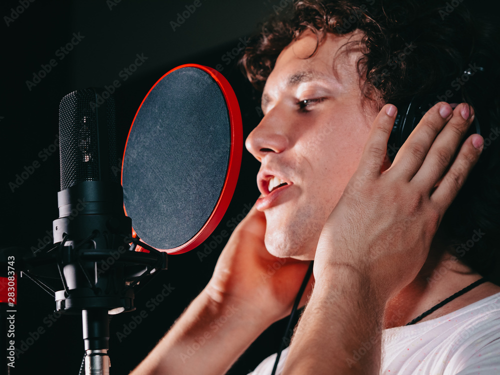 Male Vocal Artist With Curly Hair Singing Alone. Young Handsome Singer Man  Emotionally Writing Song In The Studio. Recording New Melody Or Album.  Stock Photo | Adobe Stock