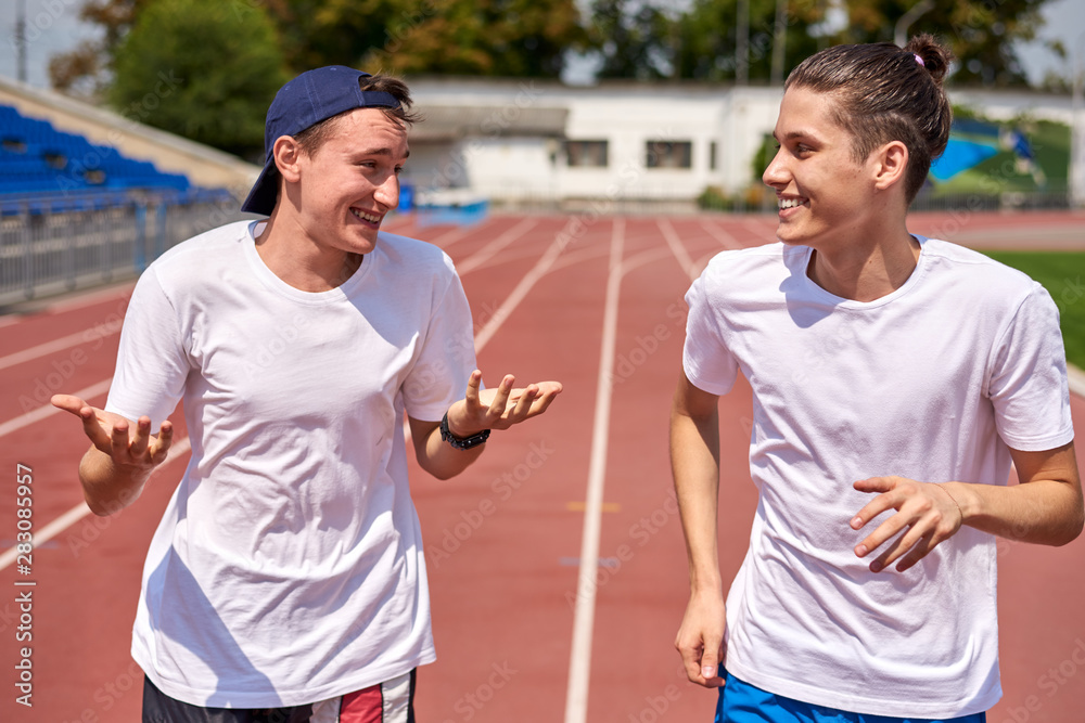 Young athletes having a talk while racing on the running track