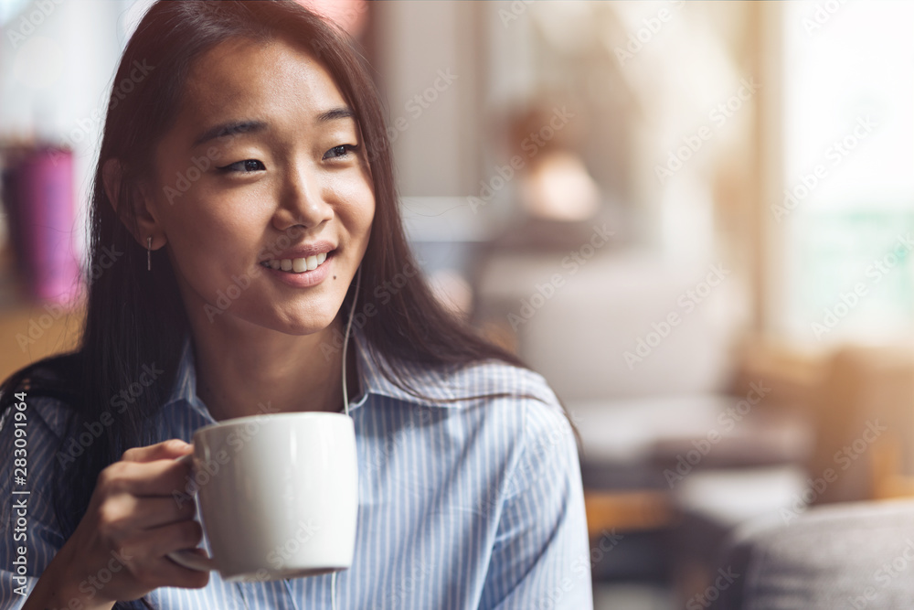 Enjoy the taste of coffee. Happy girl working at a coffee shop. Concept of female freelancer business. Copy space on the right side Enjoy the taste of coffee. Happy girl working at a coffee shop. Concept of female freelancer business. Copy space on the right side