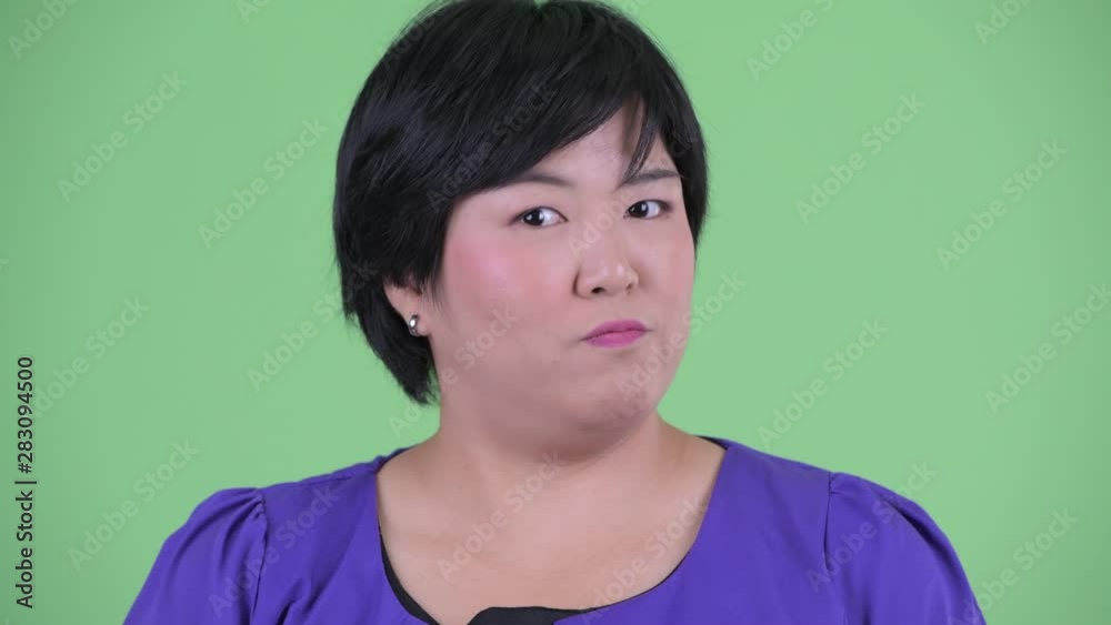 Face of serious young overweight Asian woman nodding head no Face of serious young overweight Asian woman nodding head no