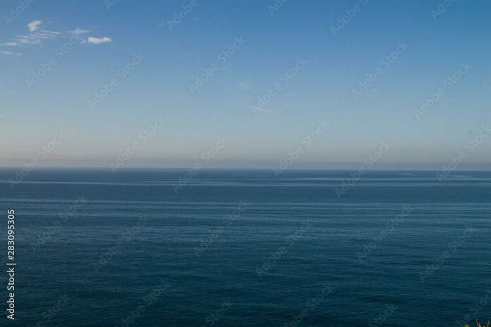 Obraz premium Current in the sea, top view. Shades of blue in the sea at the coastal current. Sea and sky, fifty shades of blue.