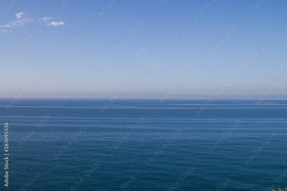 . Current in the sea, top view. Shades of blue in the sea at the coastal current. Sea and sky, fifty shades of blue.