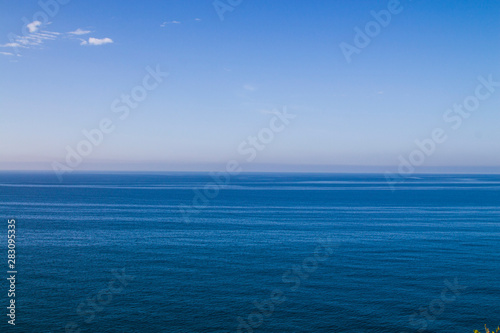 . Current in the sea, top view. Shades of blue in the sea at the coastal current. Sea and sky, fifty shades of blue.
