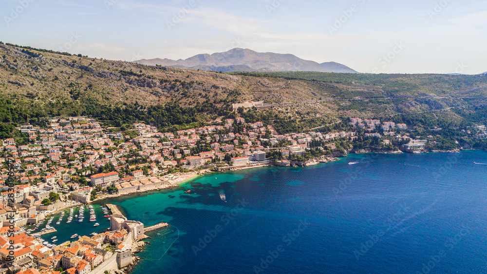 Dobrovnik, Croatia from above. Aerial drone footage of the historic city of Dubrovnik. City walls, blue sea and harbour.