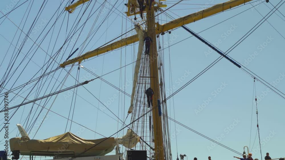 Sailors climb down a match on a beautiful sailing ship in port 4k Sailors climb down a match on a beautiful sailing ship in port 4k