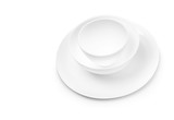 Set of white dishes on table on light background.
